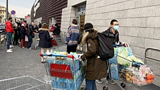 Des habitants de Milan, en Italie, portant des masques devant un supermarché, le 8 mars 2020.