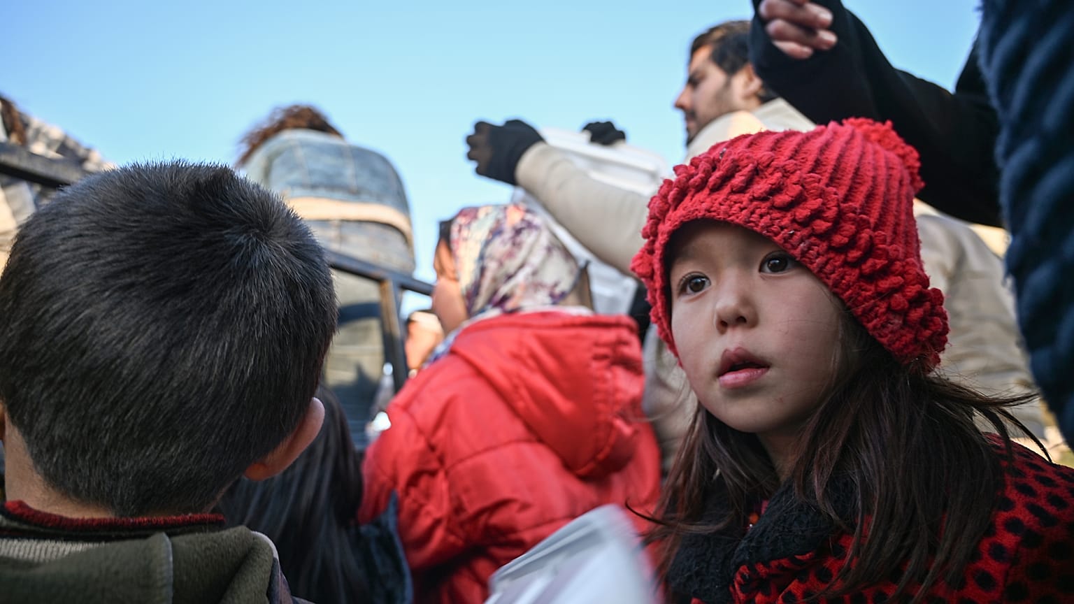 Migrant children wait with adults to receive food near Edirne, northwestern Turkey as they wait to cross the Meritsa river by boat and enter neighbouring Greece