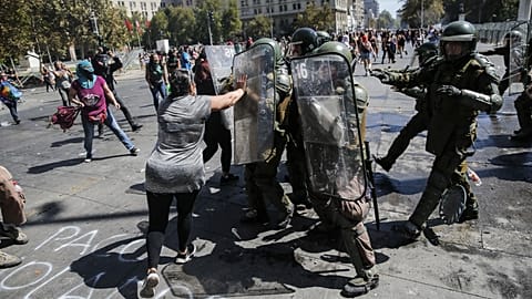 A woman struggles with riot police during clashes 