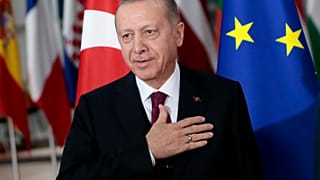 Turkish President Recep Tayyip Erdogan puts his hand over his heart in a gesture of hello prior to a meeting with European Council President Charles Michel.
