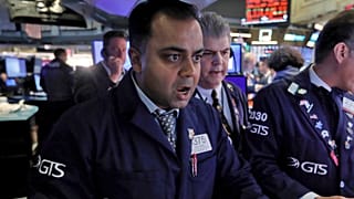 Specialist Dilip Patel, left, works at his post on the floor of the New York Stock Exchange, Monday, March 9, 2020