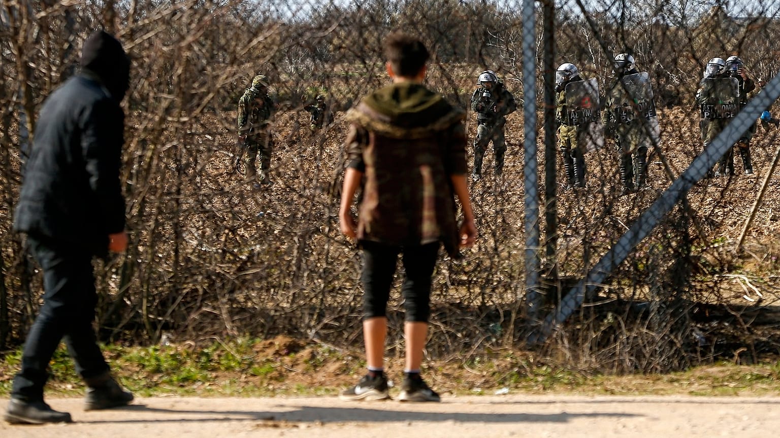 Migrants gather at a border fence on the Turkish side during clashes with the Greek riot police and army at the Turkish-Greek border in Pazarkule, Edirne region
