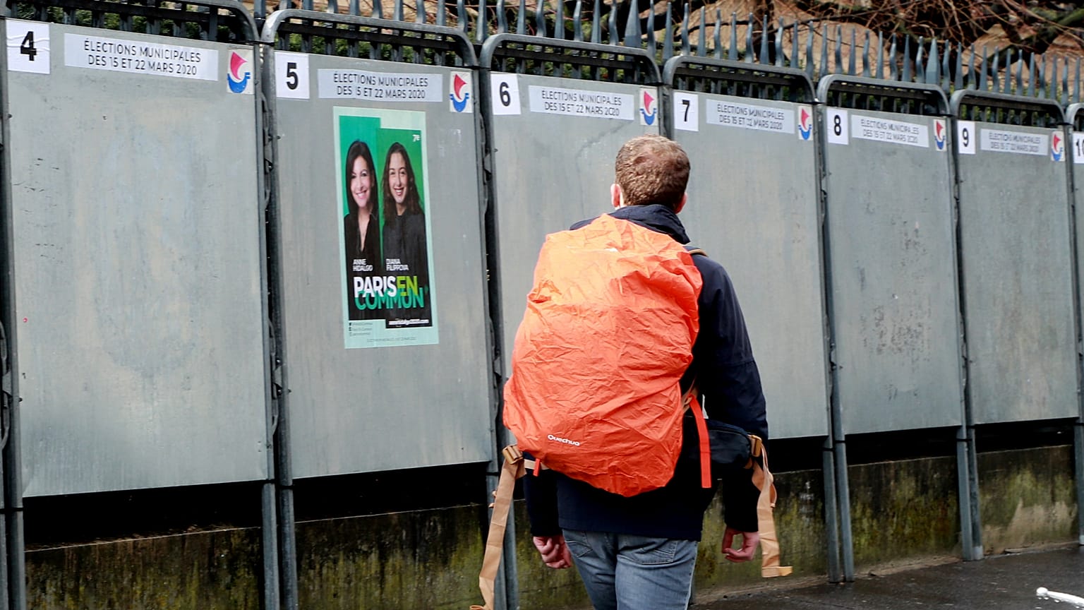 A man walks past a political poster depicting several of the candidats running in the upcoming French March 2020 mayoral elections.