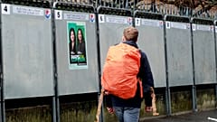 A man walks past a political poster depicting several of the candidats running in the upcoming French March 2020 mayoral elections.