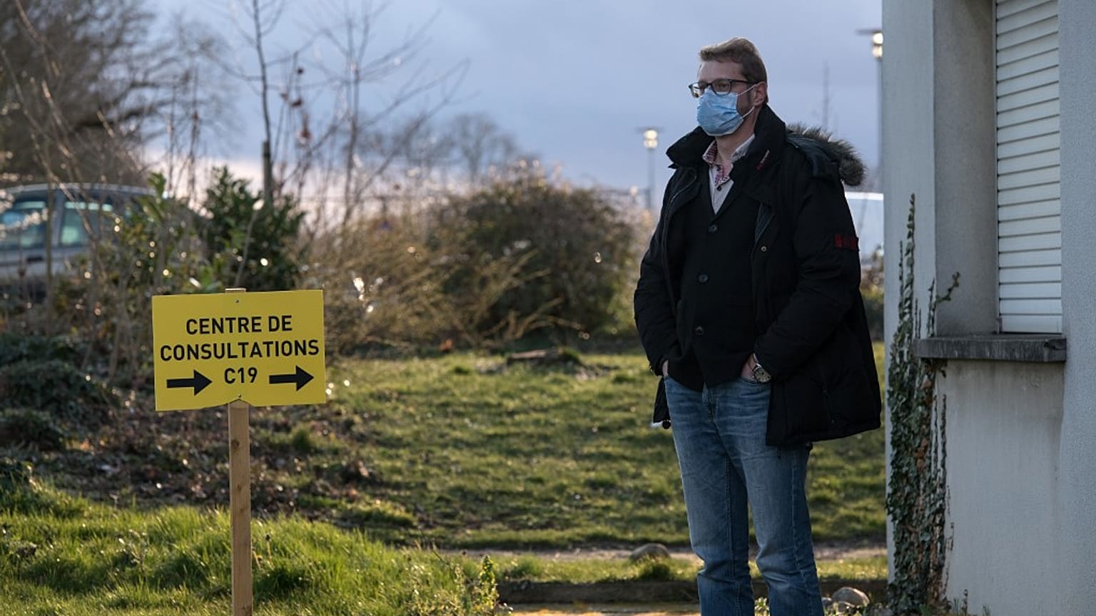 A man waits in front of the consultations center . (Photo by SEBASTIEN BOZON / AFP)