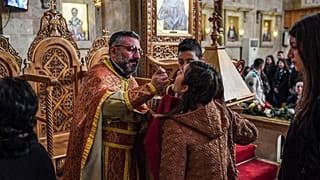 Gläubige erhalten die Kommunion während der Messe in der griechisch-orthodoxen Kirche in Aleppo, Syrien, Dezember 2019.