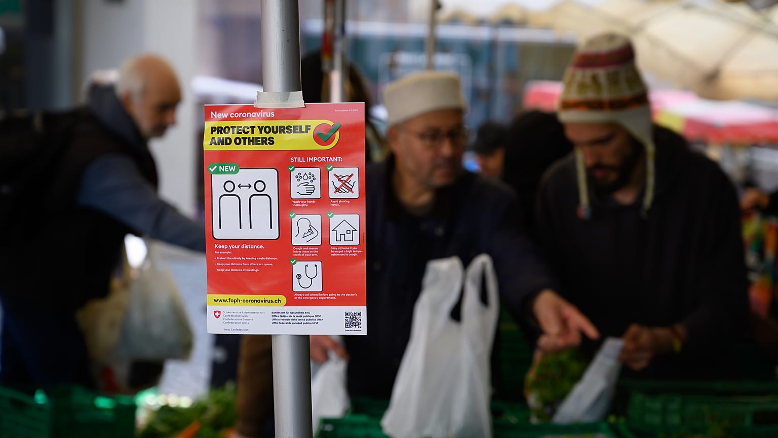 March 14, 2020 shows an information sign as eople are shopping in Saturday's market 