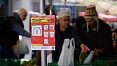 March 14, 2020 shows an information sign as eople are shopping in Saturday's market 