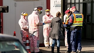 Rendőrök ellenőriznek egy Magyarországra beutazó utast a Hegyeshalomnál, a határátkelőnél 2020. március 16-án