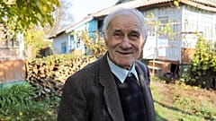 Ion Sandu, residente del viejo Cotul Morii, en Moldavia, posa frente a la casa que se negó a abandonar