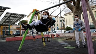 Un hombre y su hija jugando en un parque de la Roma en cuarentena