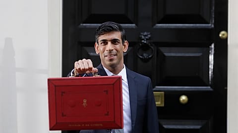 Britain's Chancellor of the Exchequer Rishi Sunak stands outside No 11 Downing Street and holds up the traditional red box that contains the budget speech for the media