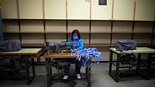 امرأة تخيط أقنعة للوجه خاصة بالفرق الطبية في كاراكاس