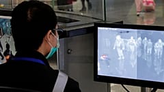 A health surveillance officer monitors passengers arriving at the Hong Kong International airport in Hong Kong