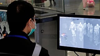 A health surveillance officer monitors passengers arriving at the Hong Kong International airport in Hong Kong
