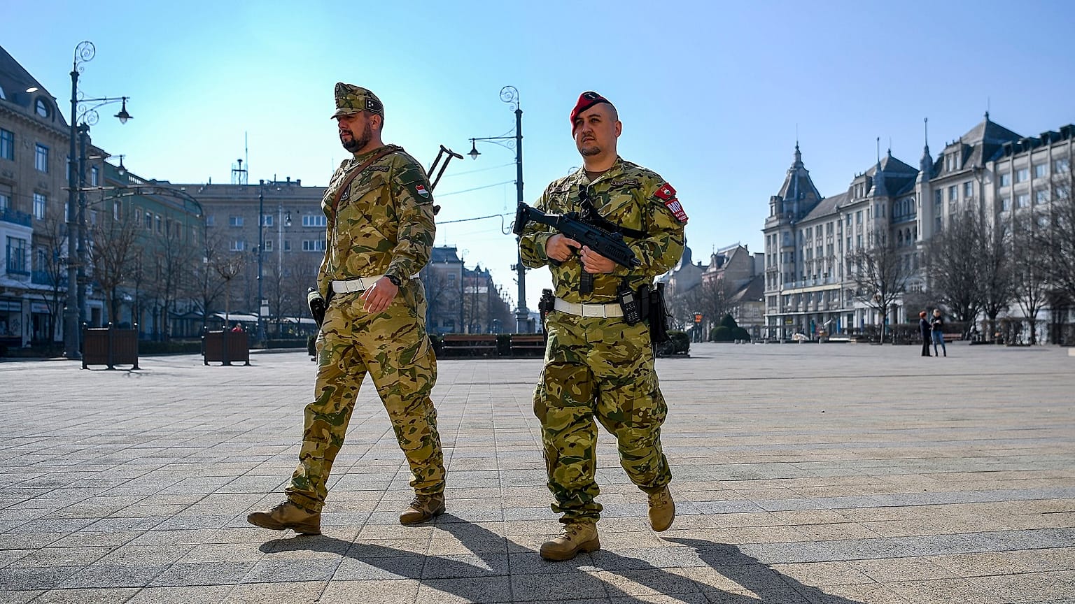 A soldier and a member of the military police walk on the main square of Debrecen, Hungary, Friday, March 20, 2020