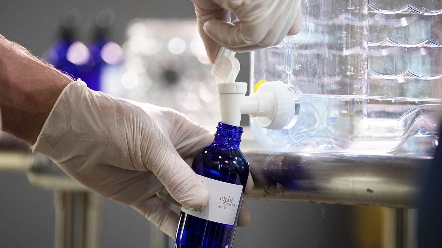 A worker bottles hand sanitizer made at the Eight Oaks Farm Distillery in the USA