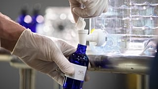 A worker bottles hand sanitizer made at the Eight Oaks Farm Distillery in the USA