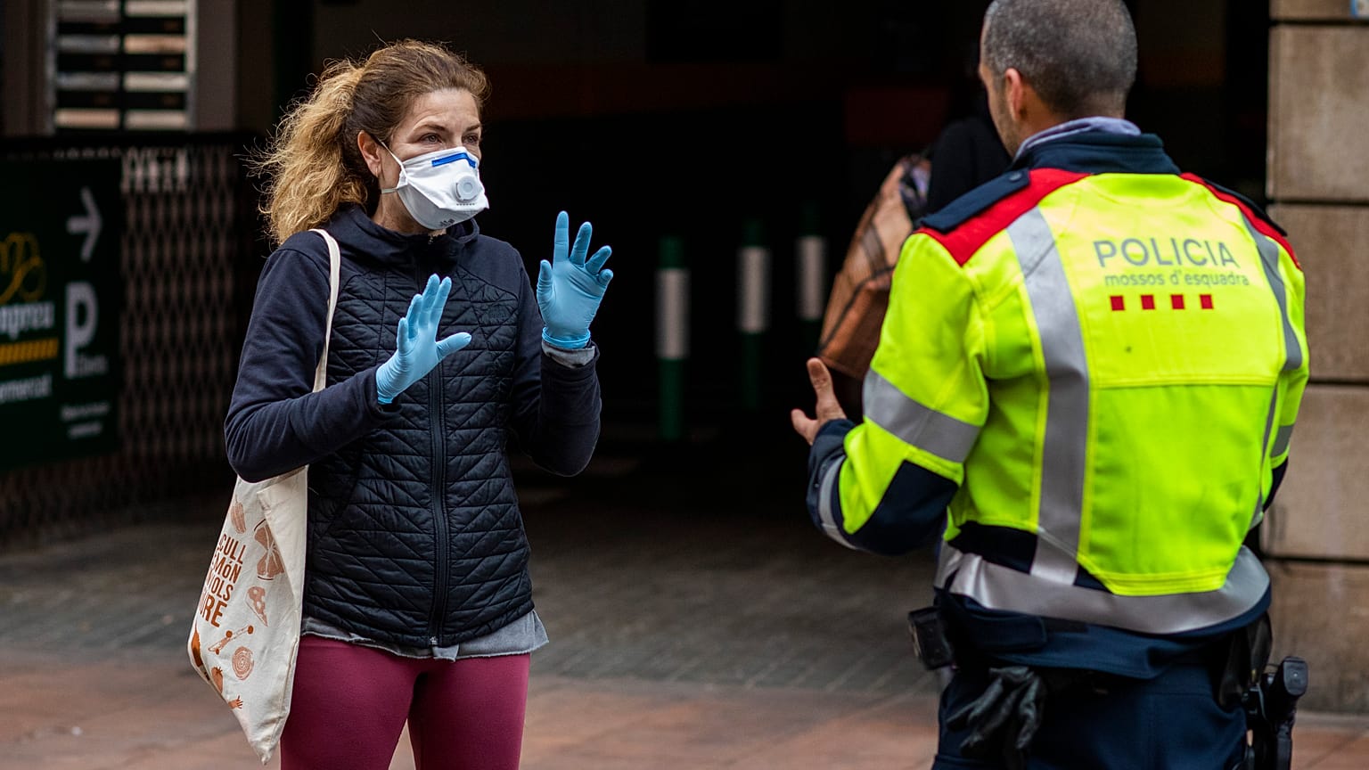 Una mujer habla con un policía en Barcelona, España, el miércoles 18 de marzo de 2020. 
