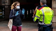 Una mujer habla con un policía en Barcelona, España, el miércoles 18 de marzo de 2020. 
