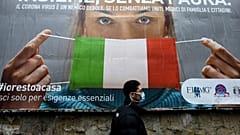A man walks past a large billboard raising awareness to the measures  