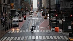 A commuter crosses 42nd Street in front of Grand Central Terminal during morning rush hour, Monday, March 23, 2020, in New York
