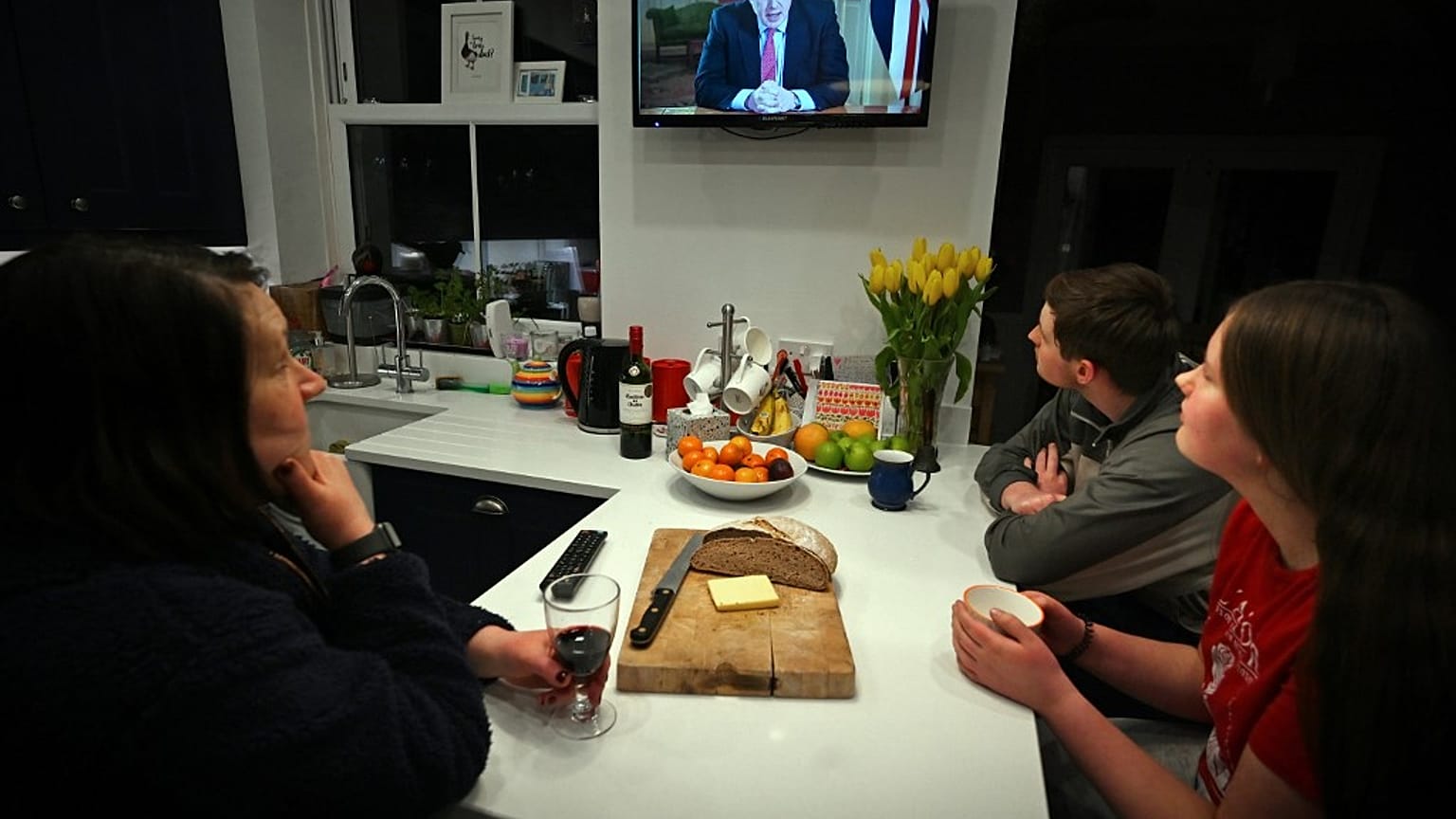 Una familia escucha el discurso televisado del primer ministro Boris Johnson