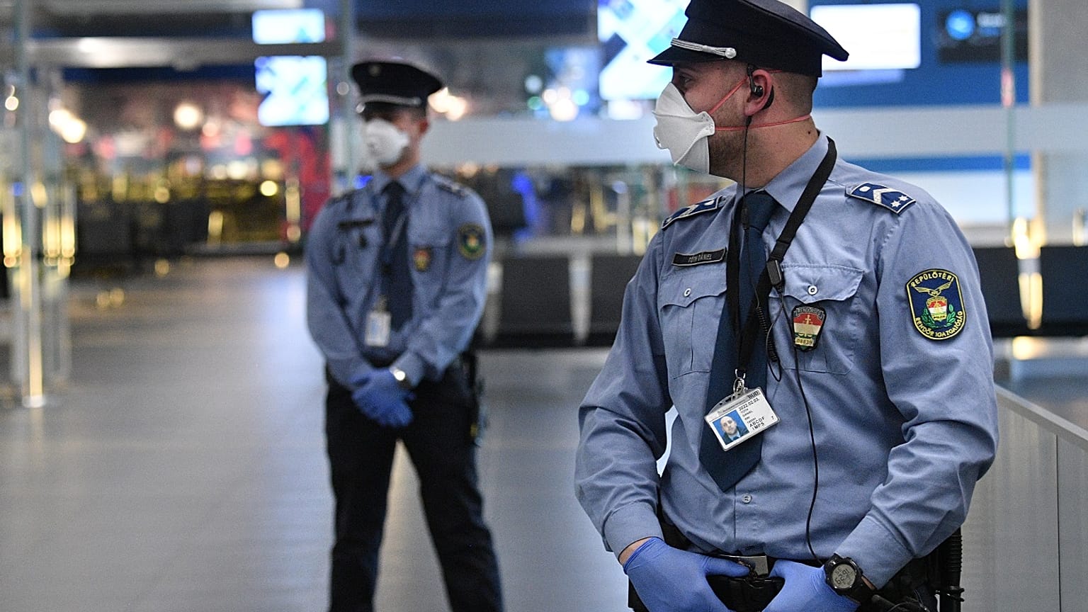 Hungarian police officers wearing protective face masks stand on guard in the hall of Budapest's Liszt Ferenc Airport of on February 5, 2020