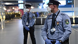 Hungarian police officers wearing protective face masks stand on guard in the hall of Budapest's Liszt Ferenc Airport of on February 5, 2020