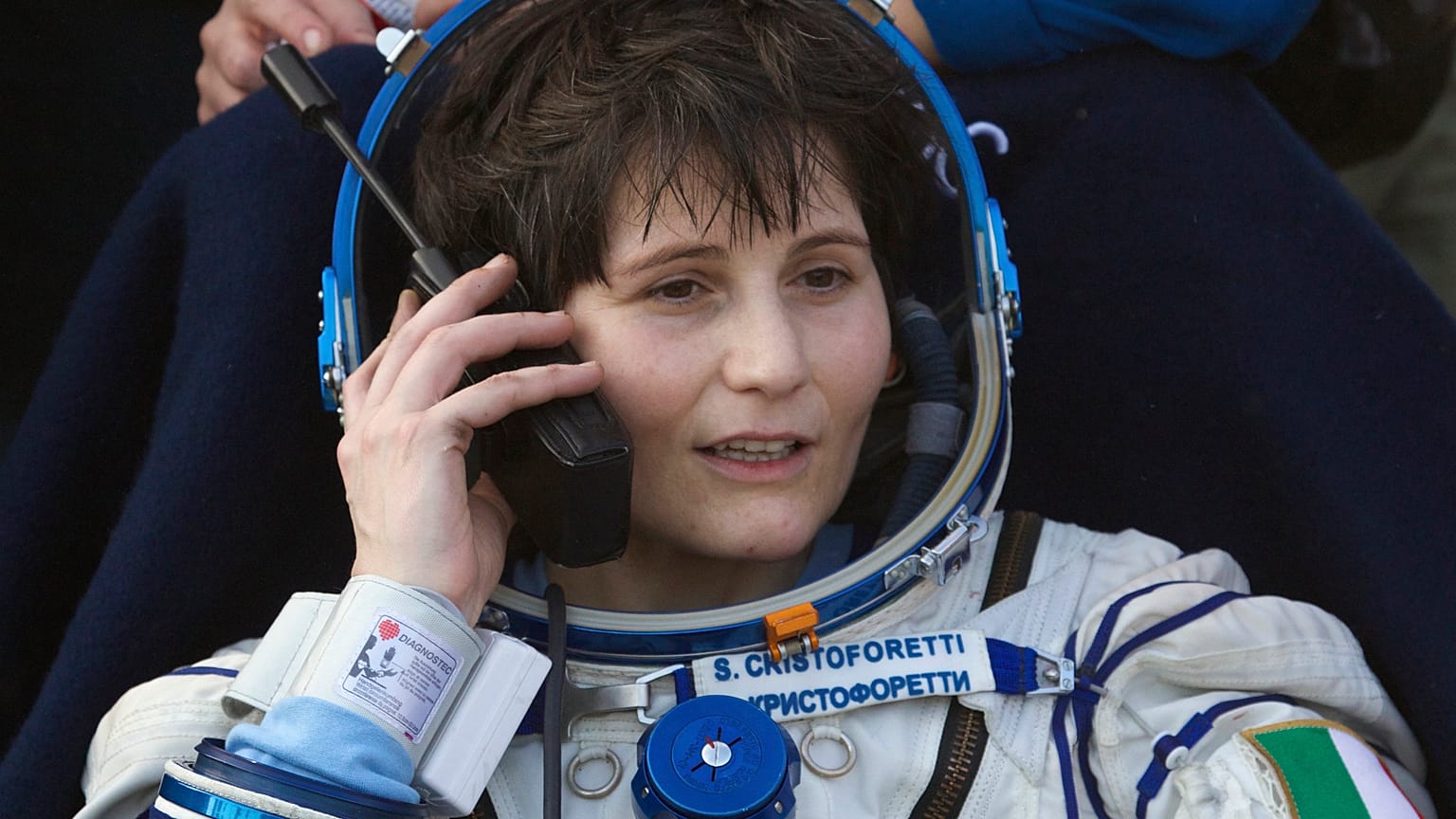 Italian astronaut Samantha Cristoforetti speaks on a satellite phone outside of the Soyuz AFP PHOTO / POOL / IVAN SEKRETAREV (Photo by IVAN SEKRETAREV / POOL / AFP)