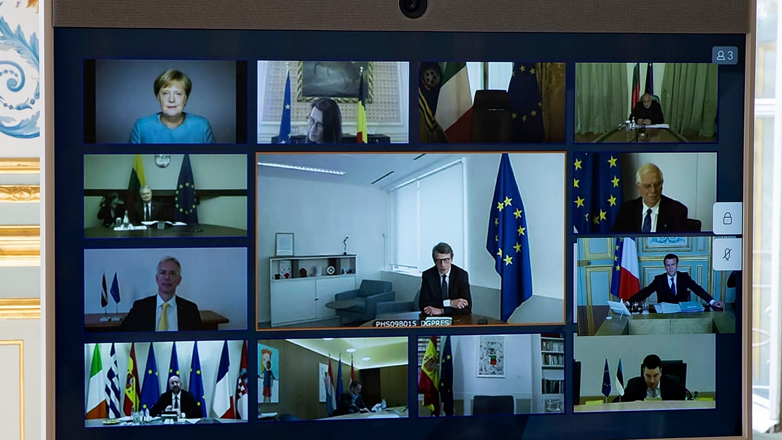 Members of the European Council are seen on the screen during a video conference call at the Elysee Palace in Paris, Thursday March, 26 2020. 