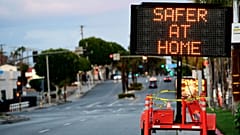 Panneau de signalisation routière recommandant indiquant "Plus en sécurité à la Maison" déployé dans les rues de Monterey Park en Californie, le 25 mars 2020.
