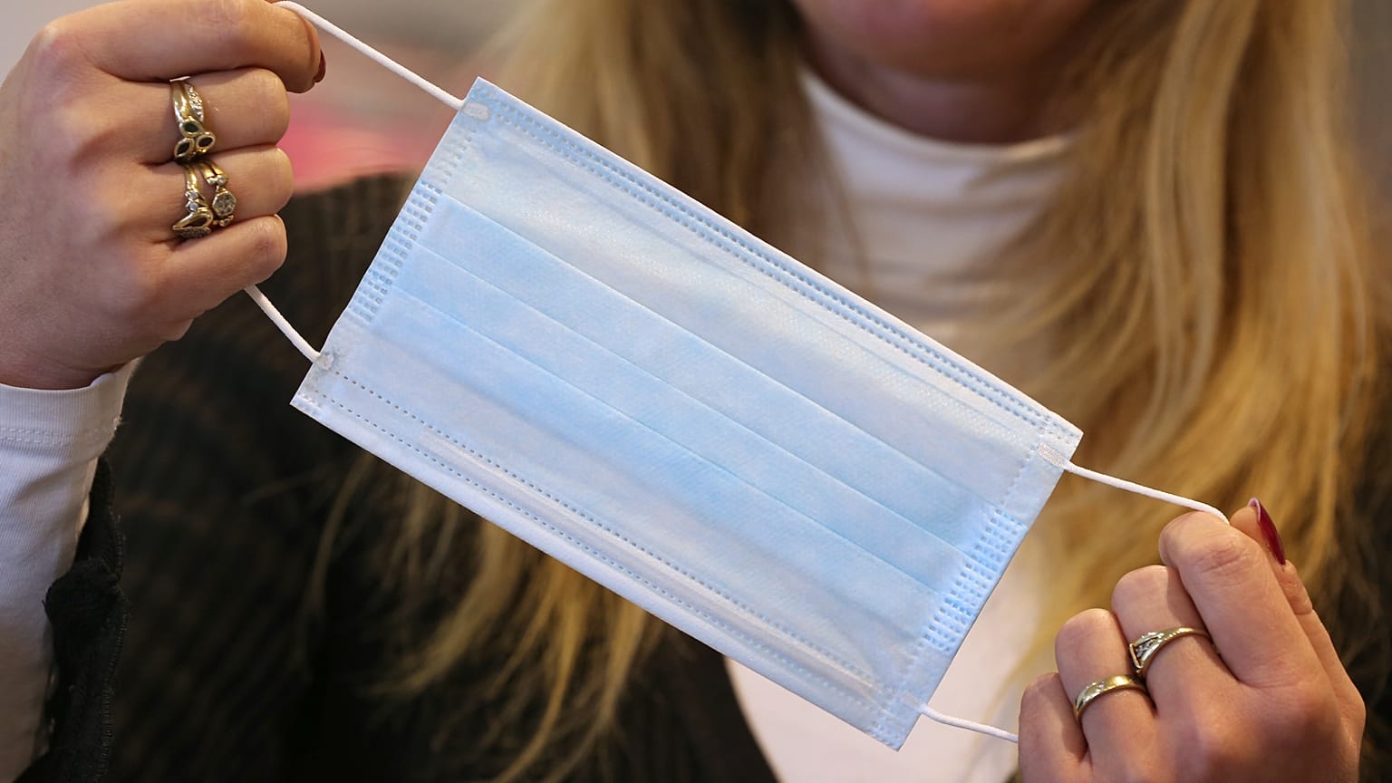 An employee shows a protective face mask on January 28, 2020 at a pharmacy in Kaufbeuren, southern Germany.