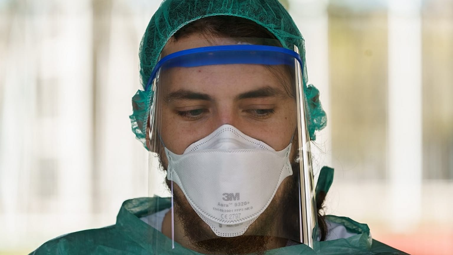 A healthcare worker dressed in protective gear waits for drivers at a drive-through testing. (Photo by CESAR MANSO / AFP)