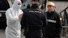 A member of UME, left, talks with a police officer at a ice-skating rink in Madrid, Spain, Tuesday, March 24, 2020.