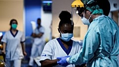 Sanitarios se ponen los equipos de protección antes de trabajar en la unidad para pacientes infectados por el COVID-19 en el Hospital Erasme de Bruselas