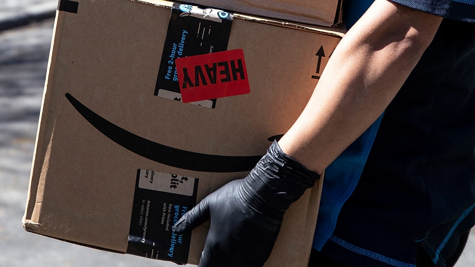 Csomagot visz házhoz az Amazon internetes kereskedelmi cég egyik kiszállítója Los Angelesben 2020. március 26-én.