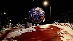 A balloon in the shape of the Earth is pictured during a mass climate protest during the COP25 summit in Madrid, December 6, 2019. (Photo by CRISTINA QUICLER / AFP)