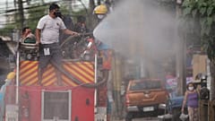 Filipinlerin başkenti Manila'da bir görevli, koronavirüsün yayılmasını önlemek amacıyla caddede dezenfekte çalışması yaparken