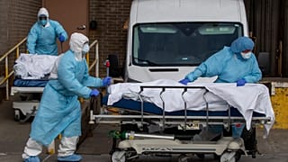 Medical personnel wearing personal protective equipment remove bodies from a medical centre in New York, 2020.