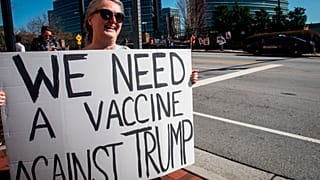 A protestor holds a sign in front of the Centers for Disease Control and Prevention headquarters on Friday, March 6, 2020 in Atlanta, Georgia.