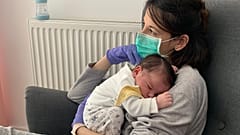 Venssa Muro eldiven ve maske ile bebeğine sarılıyor