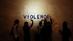 A group of women paste the word "violence" onto a street wall, part of a protest to draw attention to domestic violence, Paris, France, October 2019.
