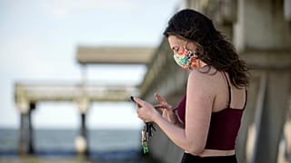Une femme envoie un message sur son téléphone portable à Tybee Island en Georgie
