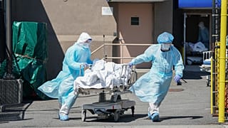 Bodies are moved to a refrigeration truck serving as a temporary morgue at Wyckoff Hospital in the Borough of Brooklyn on April 6, 2020 in New York.