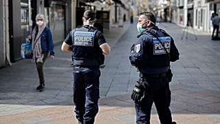Local police patrol as pedestrians wear face masks in the main street of Sceaux, south of Paris,  on April 8, 2020