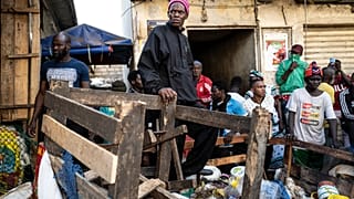 A shopkeeper watches as a bulldozer demolishes informal shops in an effort to stop the spread of the coronavirus, Dakar, Senegal, March 22, 2020.