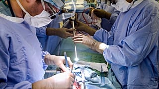 In this Tuesday, Jan. 23, 2018 file photo, a surgeon directs a special camera to be able to view his patient's cancer tumor on monitors while performing surgery at a hospital.