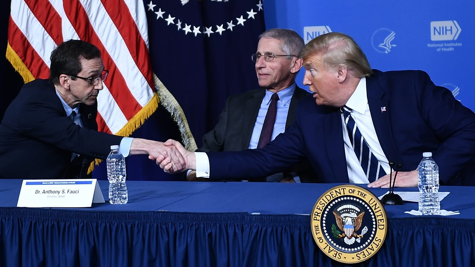 Donald Trump, amerikai elnök John Mascolának, a Vakcinakutató Központ igazgatójának a kezét rázza épp Dr. Fauci előtt