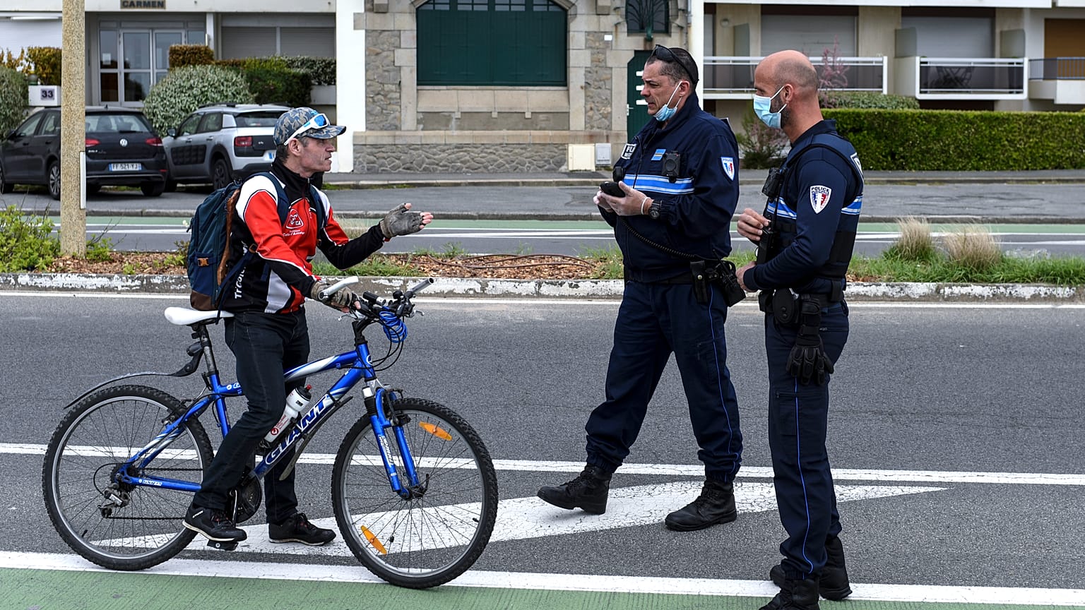A cyclist is stopped by French police controlling the lockdown at La Baule in western France, Easter Monday, April 13, 2020.